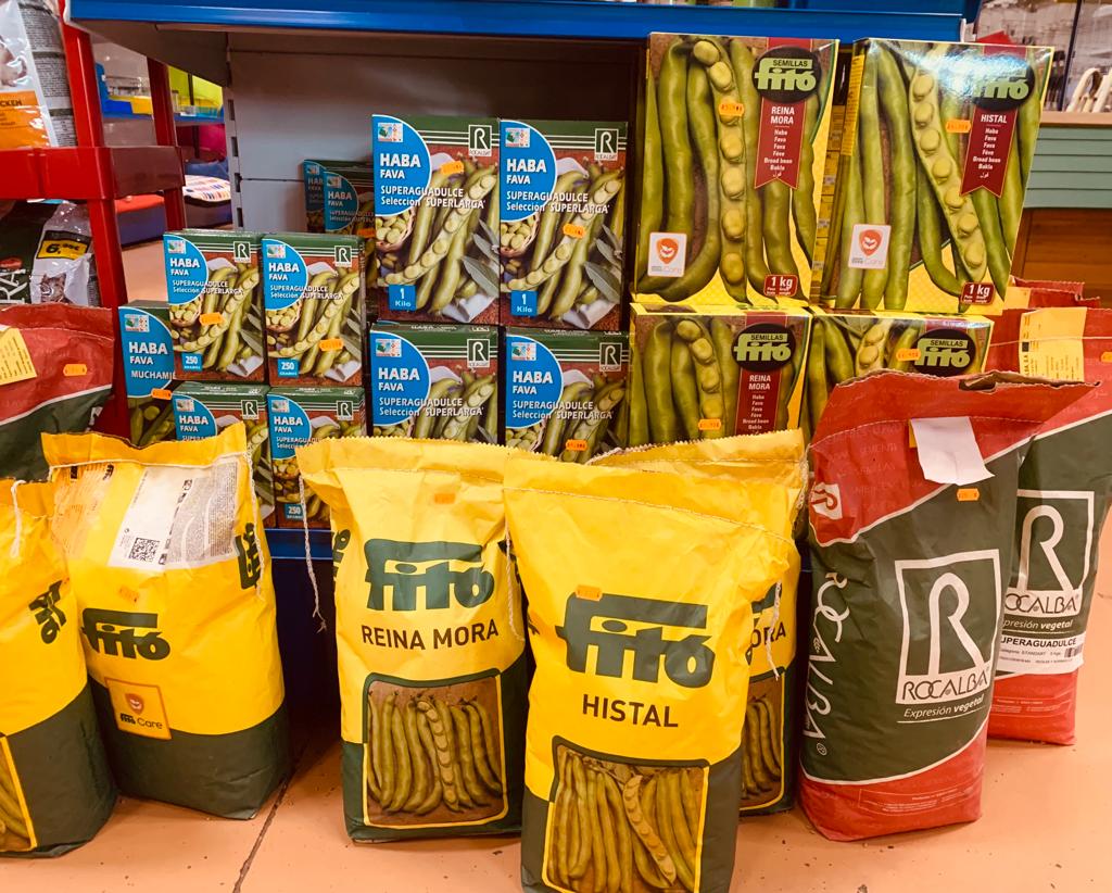 Surtido de paquetes de semillas y legumbres en una tienda de jardinería.