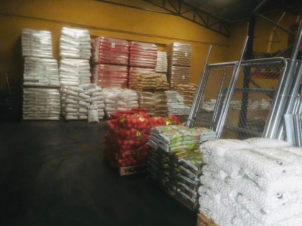 Sacos de productos agrícolas apilados en un almacén.