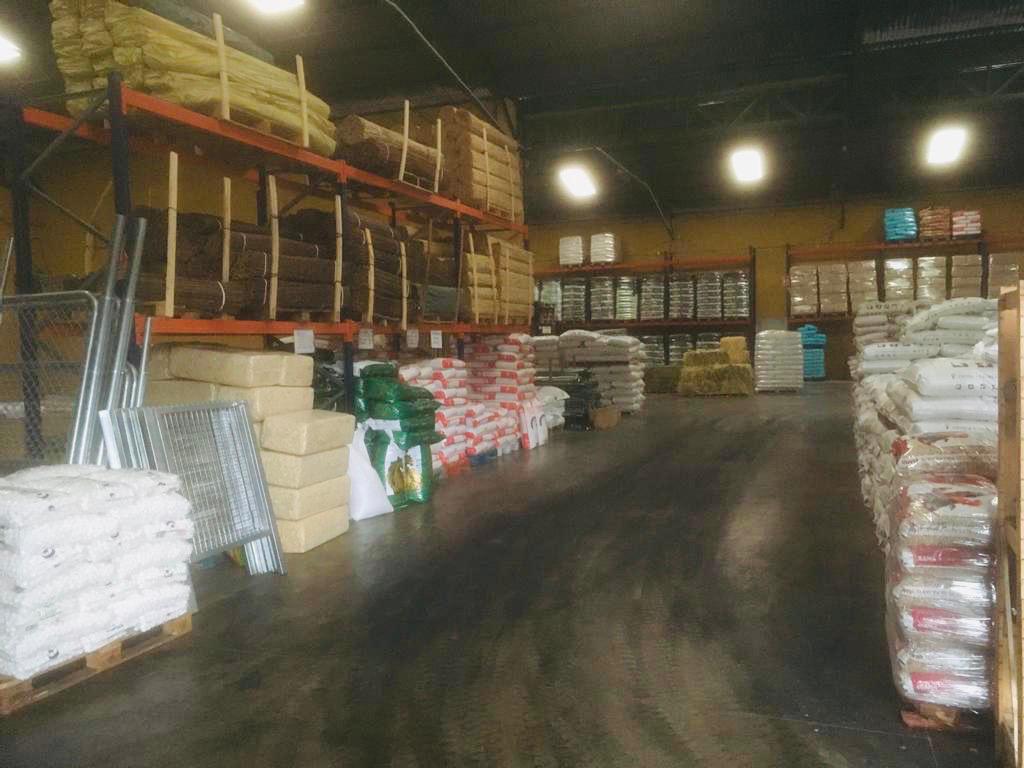 Interior de almacén agrícola con suministros organizados.